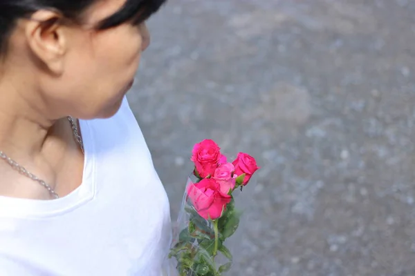 O foco seletivo e a profundidade superficial do campo de um belo buquê de rosas vermelhas mantêm-se pela mulher com o fundo de camisa branco. Amor e romance Dia dos Namorados conceito . — Fotografia de Stock