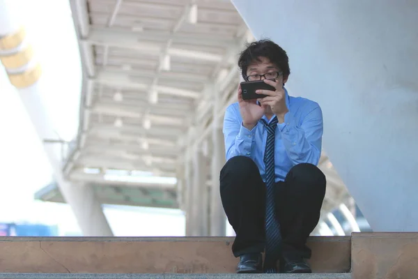 Mobil akıllı telefon iş arayan işsiz genç Asyalı adam. İşsizlik kavramı. — Stok fotoğraf