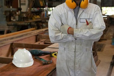 Kendine güvenen genç bir işçi beyaz üniformalı portresi doğrama Atölyesi göğsünden bir kol karşıya.