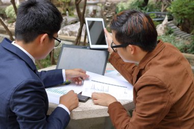 Mermer parkta oturan ve dizüstü bilgisayar, tablet ve çizelgeler ile çalışma iş takım.