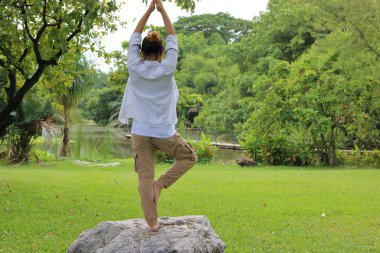 Genç adam güzel park açık Rock'da Yoga meditasyon pratik.