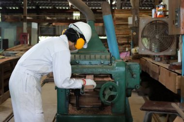 Profesyonel genç işçi beyaz Emanet üniformalı fabrikasında makine rende ile çalışma.