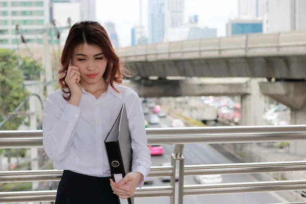 Портрет привлекательной молодой азиатской деловой женщины, разговаривающей по телефону в городском здании города на фоне копировального пространства . — стоковое фото