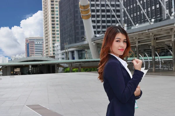 Framgångsrika affärsidé. Självsäker ung asiatisk affärskvinna ständiga och leende bygga staden bakgrund. — Stockfoto
