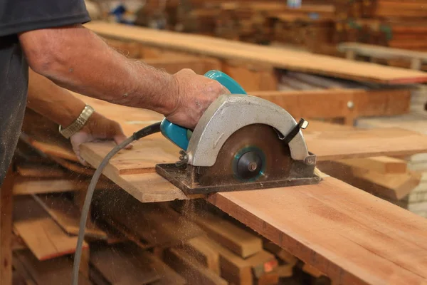 Eller üst düzey marangoz marangozluk marangozluk elektrik daire testere karşı ahşap bir parça kesme kapatın. Ağaç işleme kavramı — Stok fotoğraf