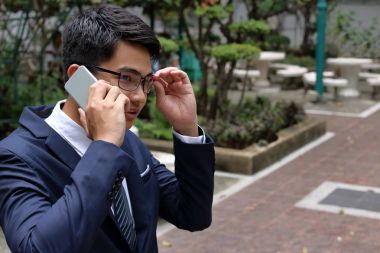 Yakışıklı buinessman cep telefonuna Şehir Parkı konuşurken.