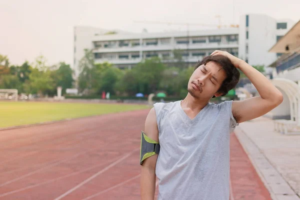 Saludable joven corredor asiático calentando antes de correr en pista en el estadio — Foto de Stock