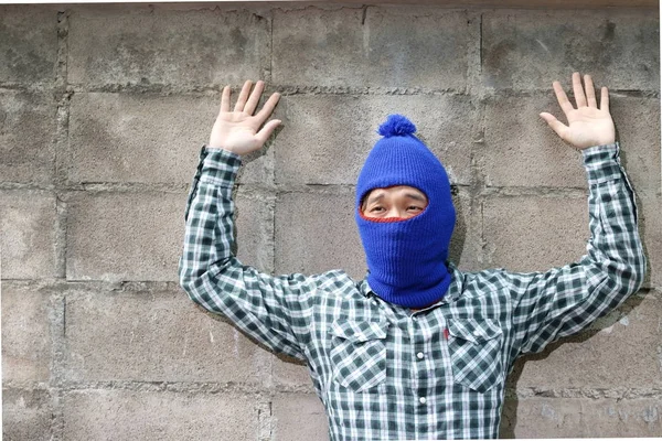 Ladrão mascarado levantou os braços com fundo de parede de tijolo. Conceito de ladrão de captura . — Fotografia de Stock
