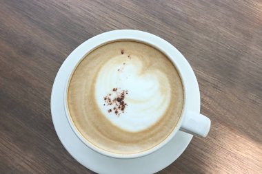 Sıcak kahve latte sanat kapuçino üstten görünüm ahşap arka plan üzerinde.