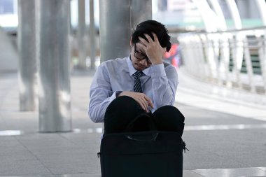 Kaldırım office katta oturan ve iş ile yorgun hissetme sinirli stresli genç Asyalı adam portresi