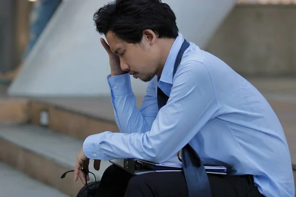 Nahaufnahme gestresster frustrierter junger asiatischer Mann, der auf der Treppe sitzt. er fühlt sich von etwas enttäuscht oder müde. — Stockfoto