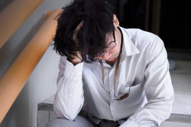 Kafasına dokunmak ve iş ile yorgun hissetme sinirli stresli genç Asya iş adamı.