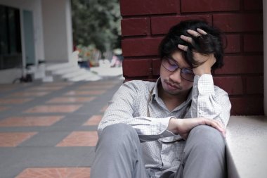 Hayal kırıklığına uğramış genç Asyalı adam baş ve duygu disappionted dokunmadan veya yorgun vurguladı. İşsiz işadamı kavramı.