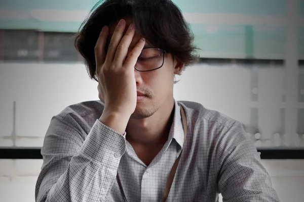 Vorderansicht von frustrierten gestressten jungen asiatischen Geschäftsmann, der sein Gesicht mit Händen bedeckt und sich mit dem Job müde fühlt. — Stockfoto