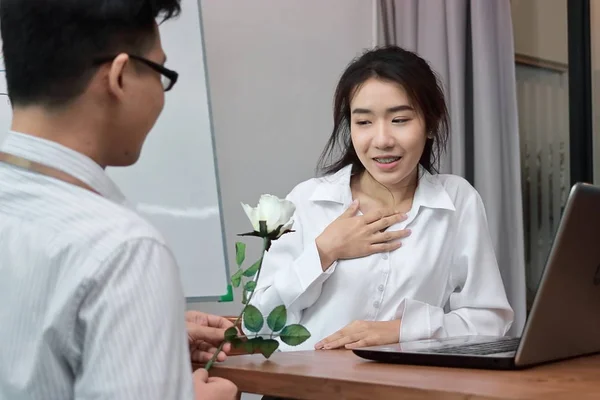 Doux foyer de jeune femme asiatique attrayante excitée d'obtenir une rose blanche au bureau le jour de la Saint-Valentin. Amour et romance en milieu de travail concept . — Photo