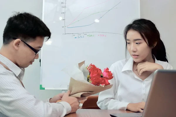 Привлекательная молодая азиатка, принимающая букет красных роз от своего бойфренда в день Святого Валентина. Любовь и романтика в концепции рабочего места . — стоковое фото
