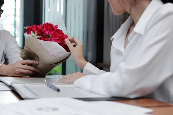 Винтажный тонизирующий образ привлекательной молодой азиатки, принимающей букет красных роз от бойфренда в офисе на День Святого Валентина. Любовь и романтика в концепции рабочего места . — стоковое фото