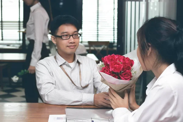 Винтажный тонизирующий образ веселой молодой азиатки, принимающей букет красных роз от бойфренда с завистливым женским фоном на день Святого Валентина. Любовь и романтика в концепции рабочего места . — стоковое фото