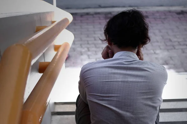 Visão traseira de frustrado estressado jovem homem de negócios asiático sentindo-se tentado ou exausto na escada do escritório . — Fotografia de Stock