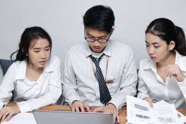 Önden Görünüm birlikte ofisinde bir dizüstü bilgisayarda çalışan genç Asya iş adamları. Ekip çalışması brainstroming kavramı. Seçici odak ve sığ derinlik-in tarla.