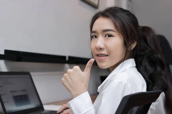 Уверенная молодая азиатская деловая женщина, показывающая громкую вывеску на рабочем месте . — стоковое фото