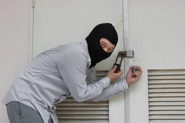 Ladrón enmascarado usando un pasamontañas escapando después de colarse en la casa. Concepto de crimen — Foto de Stock