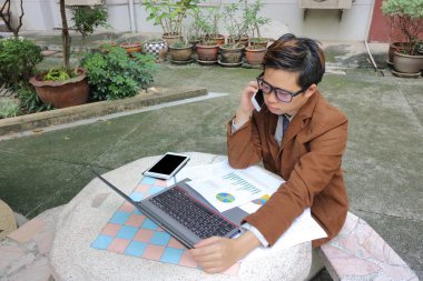 Müşteri ile telefonda konuşurken yakışıklı genç iş adamı.