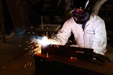 Beyaz üniforma koruyucu kask kaynak kıvılcım atölye ile çelik ile profesyonel Kaynakçı önden görünümü. Sanayi işçisi kavramı.