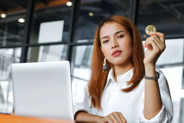 Выборочный фокус на руке азиатской бизнес-женщины, держащей криптовалюту золотой биткойн в офисе. Виртуальные деньги на цифровые . — стоковое фото