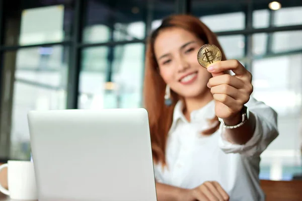 Рука азиатской бизнес-леди показывает криптовалюту золотой биткойн в офисе. Виртуальные деньги на цифровые . — стоковое фото