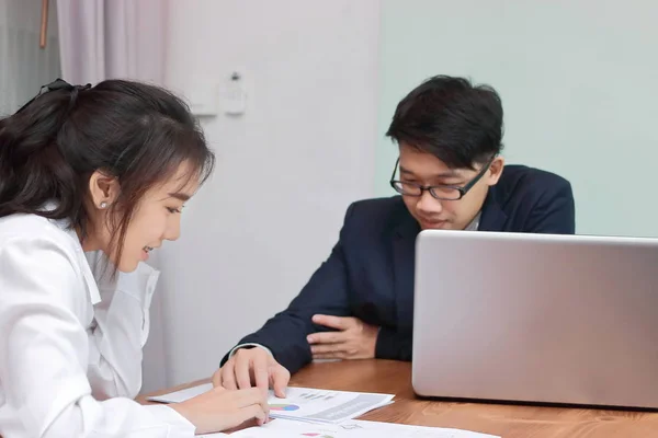 Deux jeunes gens d'affaires asiatiques analysant des documents ou des graphiques ensemble dans un bureau moderne. Concept d'entreprise de travail d'équipe. Concentration sélective et faible profondeur de champ . — Photo