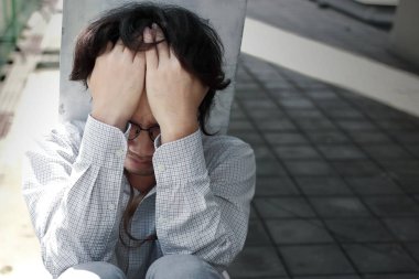 Sad Önden Görünüm genç Asya iş adamı elleriyle yüzünü kaplayan depresif.