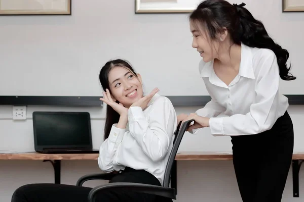 Веселая молодая азиатская деловая женщина толкает стул и веселится вместе в офисе . — стоковое фото