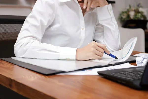 Обрезанное изображение рук деловой женщины, анализирующей диаграммы или информацию о рабочем месте в офисе . — стоковое фото