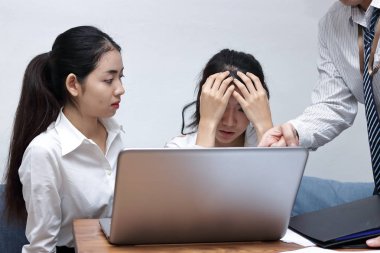 Hayal kırıklığına uğramış genç Asya iş kadını ofiste meslektaşı ile ciddi sorun acı yüzündeki elleriyle vurguladı.