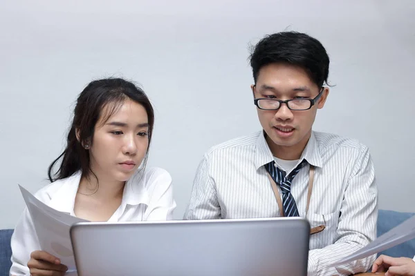 Два молодых азиатских бизнесмена работают с ноутбуками вместе в современном офисе. Концепция командной работы. Селективная фокусировка и мелкая глубина резкости . — стоковое фото