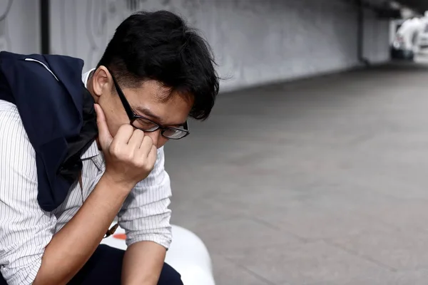 Frustrated stressed young Asian business man suffering from severe trouble
