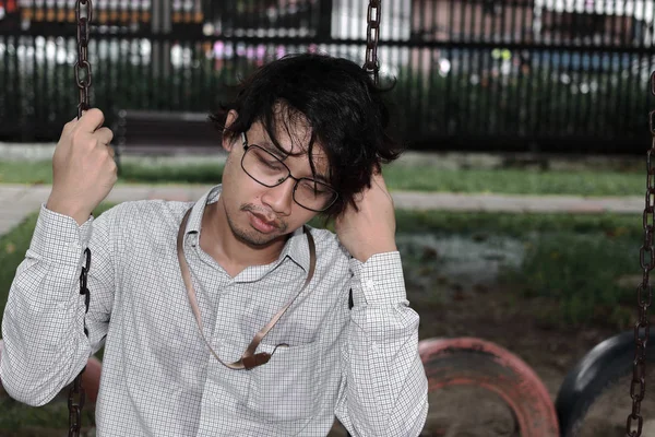 Tired depressed Asian businessman sit  in park. Unemployment business concept. — Stockfoto