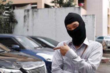 Arabaya girmeye çalışan siyah yün maskeli hırsız