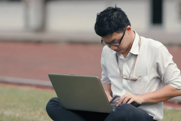 Bekerja keras orang bisnis Asia menggunakan laptop di rumput hijau . — Stok Foto