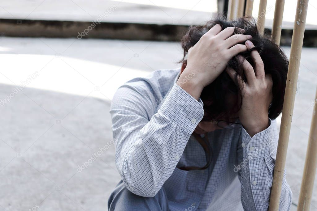 Tired stressed young Asian business man in depression with hands on forehead