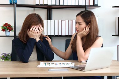 Genç Asyalı kadın ofiste onu üzgün depresif meslektaşları rahatlatıcı.