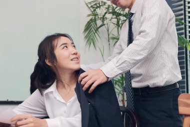 Aşkın ofiste başlaması. Çekici genç Asyalı kadın iş yerinde erkek arkadaşıyla iyi hissediyor..