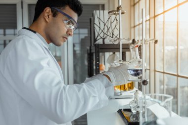 Genç erkek bilim adamları modern biyoloji laboratuvarında araştırma yapıyorlar..