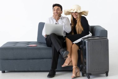 Gülümseyen çift oturuyor ve tatil planları yapıyor. Yaz tatili kavramı.
