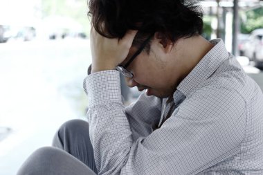 Üzgün ve endişeli Asyalı genç adam ağır depresyondan muzdarip.