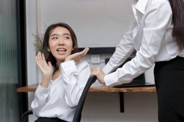 İki oyuncu Asyalı iş kadını koltukta birlikte oynuyorlar..