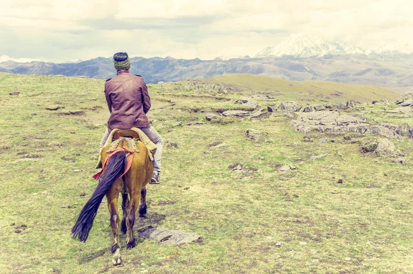 Hombre tibetano a caballo en las tierras altas tibetanas en China — Foto de Stock