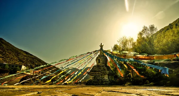 Naplemente alatt tibeti sztúpa ima zászlók — Stock Fotó