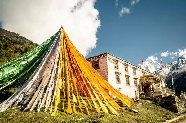 Буддийские молитвенные флаги и традиционный тибетский дом — стоковое фото